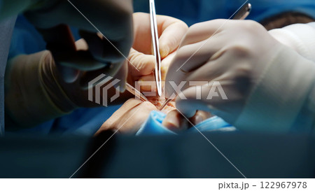 Surgeons collaborate in the or, utilizing specialized instruments to perform precise surgery Surgeons collaborate in the or, utilizing specialized instruments to perform precise surgery 122967978