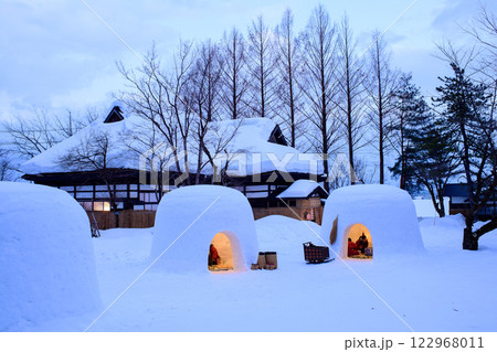 夕刻　明かりを灯したかまくらと古民家　秋田県　 122968011