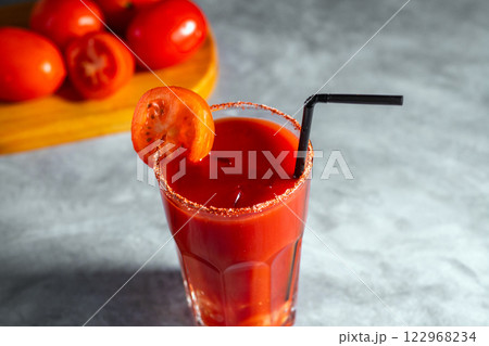 Bloody Mary cocktail in glass served with tomato slice on grey stoned surface. Red cocktail. Alternative taste. Dirty dump drink Bloody Mary cocktail in glass served with tomato slice on grey stoned surface. Red cocktail. Alternative taste. Dirty dump drink 122968234