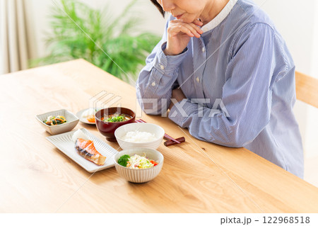 和食の朝食を前に悩むミドル女性 122968518