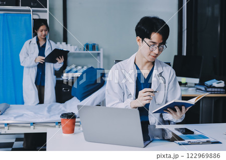 Positive doctor working on laptop in medical office, portrait. Positive doctor working on laptop in medical office, portrait. 122969886