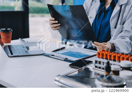 Positive doctor working on laptop in medical office, portrait. Positive doctor working on laptop in medical office, portrait. 122969900