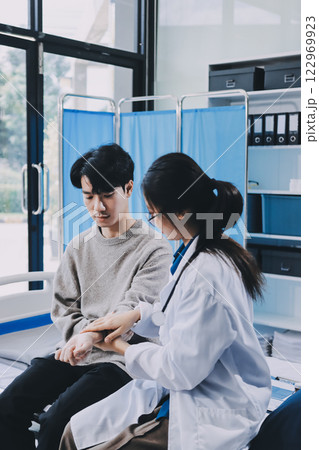 Female physician reads medical history while visiting her patient Female physician reads medical history while visiting her patient 122969923