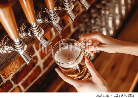 A Refreshing and Delicious Beer Being Skillfully Poured at a Charming Rustic Bar Setting 122970802
