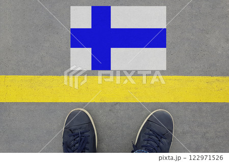 Word Start on an asphalt road with the Finnish flag  and legs in shoes.  122971526