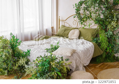 Cozy bedroom adorned with lush greenery and natural spring decor for tranquil atmosphere Cozy bedroom adorned with lush greenery and natural spring decor for tranquil atmosphere 122971851