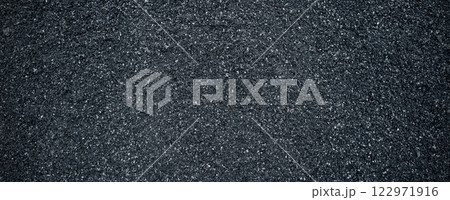 Black volcanic stone. Surface of basalt or granite close-up. Dark rough and textured rock. 122971916