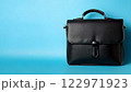 水色背景の黒いビジネスバッグ/コピースペース 122971923
