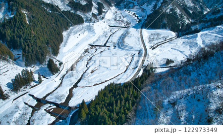 冬の富山県東部を流れる小川の上流にある朝日小川ダム周辺の空撮 122973349