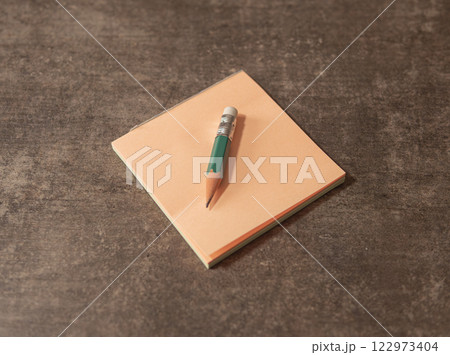 Note pad and pencil on a wooden table Note pad and pencil on a wooden table 122973404