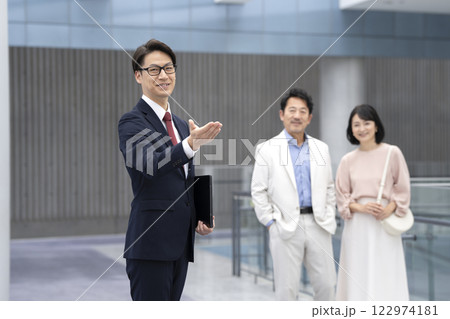 50代の夫婦を案内する営業マン 122974181