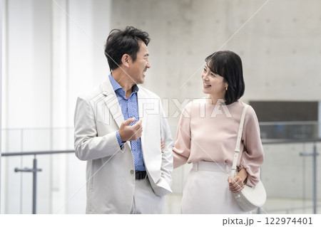 笑顔で会話をしながら歩く50代の夫婦 笑顔で会話をしながら歩く50代の夫婦 122974401