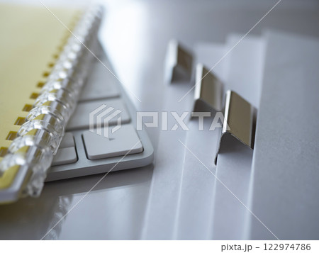 テーブルに置かれた書類とキーボードと手帳 122974786