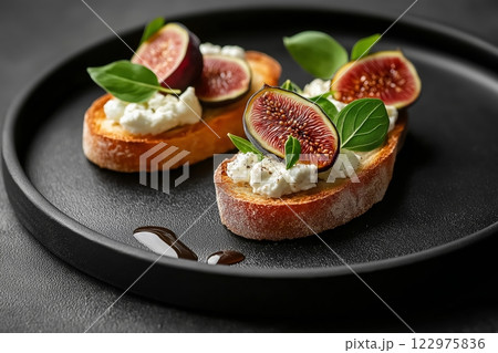 Minimalist food presentation featuring figs and cheese on toasted bread 122975836