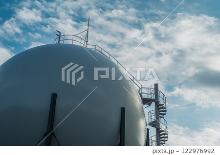 空に広がる雲とガスタンク 122976992