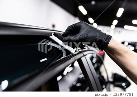 Car wash or detailing studio employee applies ceramic or graphene coating  122977781