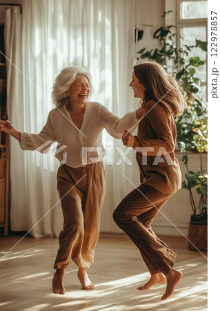 An elderly mother and her daughter joyfully dancing 122978857