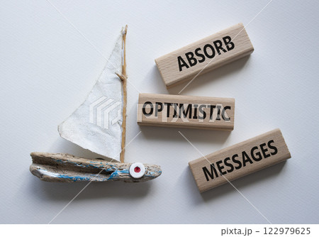 Absorb optimistic Messages symbol. Concept words Absorb optimistic Messages on wooden blocks. Beautiful white background with boat. Business and Absorb optimistic Messages concept. Copy space. 122979625