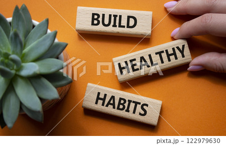 Healthy habits symbol. Concept word Build Healthy habits on wooden blocks. Doctor hand. Beautiful orange background with succulent plant. Healthy lifestyle and Healthy habits concept. Copy space 122979630