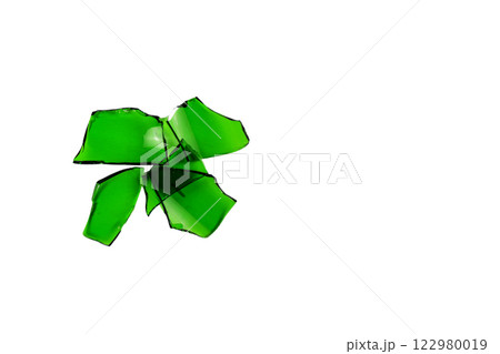 Sharp and jagged pieces of broken green glass cut out on a white background, symbolizing fragility and caution. 122980019