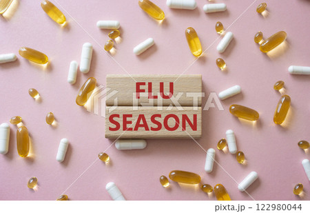 Flu Season symbol. Concept word Flu Season on wooden blocks. Beautiful pink background with pills. Medicine and Flu Season concept. Copy space Flu Season symbol. Concept word Flu Season on wooden blocks. Beautiful pink background with pills. Medicine and Flu Season concept. Copy space 122980044