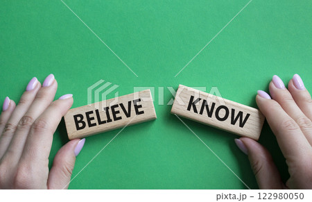 Believe or Know symbol. Concept word Believe or Know on wooden blocks. Businessman hand. Beautiful green background. Business and Believe or Know concept. Copy space 122980050