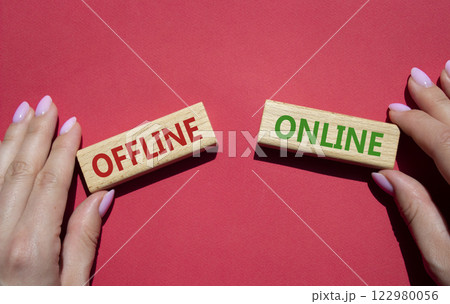 Offline or Online symbol. Concept word Offline or Online on wooden blocks. Businessman hand. Beautiful red background. Business and Offline or Online concept. Copy space 122980056