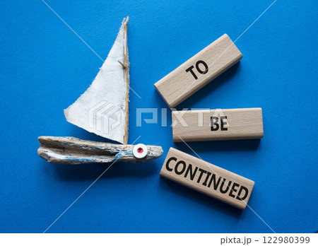 To be continued symbol. Concept words To be continued on wooden blocks. Beautiful blue background with boat. Business concept and To be continued. Copy space. 122980399
