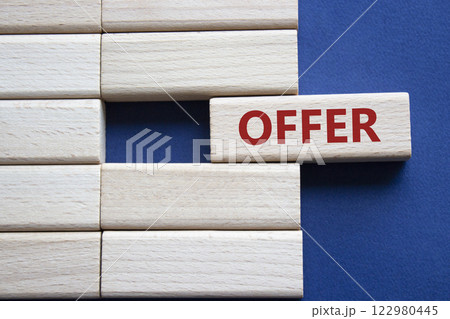 Offer symbol. Concept word offer on wooden blocks. Beautiful deep blue background. Business and offer concept. Copy space. Offer symbol. Concept word offer on wooden blocks. Beautiful deep blue background. Business and offer concept. Copy space. 122980445