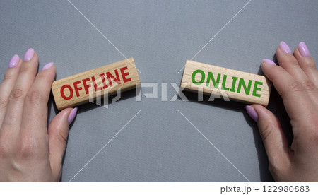 Offline or Online symbol. Concept word Offline or Online on wooden blocks. Businessman hand. Beautiful grey background. Business and Offline or Online concept. Copy space 122980883
