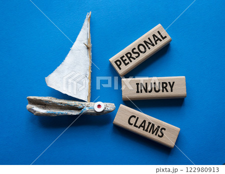 Personal Injury Claims symbol. Concept words Personal Injury Claims on wooden blocks. Beautiful blue background with boat. Business concept and Personal Injury Claims. Copy space. 122980913