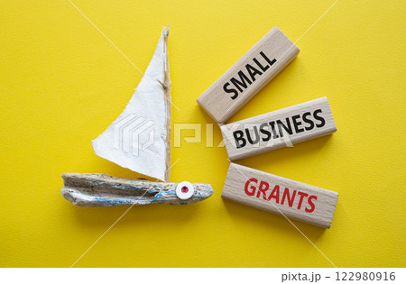 Small Business Grants symbol. Concept words Small Business Grants on wooden blocks. Beautiful yellow background with boat. Business concept and Small Business Grants. Copy space. 122980916