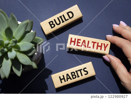 Healthy habits symbol. Concept word Build Healthy habits on wooden blocks. Doctor hand. Beautiful deep blue background with succulent plant. Healthy lifestyle and Healthy habits concept. Copy space 122980927