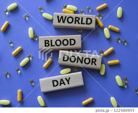 World Blood Donor Day symbol. Concept word World Blood Donor Day on wooden blocks. Beautiful purple background with pills. Medicine and World Blood Donor Day concept. Copy space 122980955