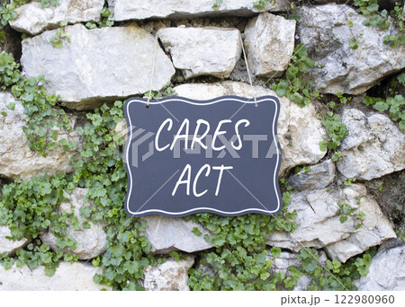 Cares Act symbol. Stone wall with words Cares Act. Beautiful stone background with plants. Business and Cares Act concept. Copy space. Cares Act symbol. Stone wall with words Cares Act. Beautiful stone background with plants. Business and Cares Act concept. Copy space. 122980960