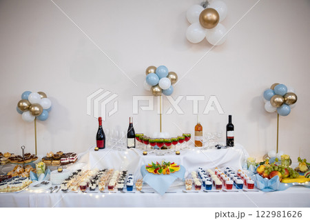 An Elegant Party Table Setup Featuring an Array of Delicious Treats Alongside Drinks An Elegant Party Table Setup Featuring an Array of Delicious Treats Alongside Drinks 122981626