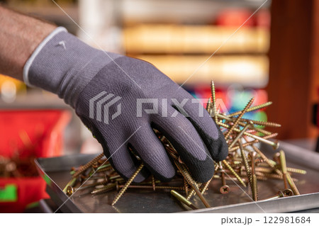 Hand Sorting Various Types of Metal Fasteners in a Dedicated Workshop Setting Environments 122981684