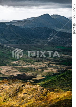 Stunning view of verdant valleys and rugged mountains in a remote landscape during overcast weather. Stunning view of verdant valleys and rugged mountains in a remote landscape during overcast weather. 122982237