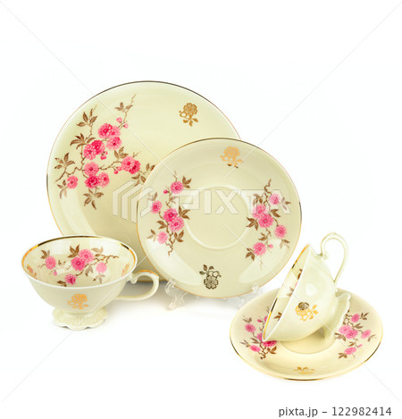 Vintage porcelain cups and saucers isolated on white background. Free space for text. Vintage porcelain cups and saucers isolated on white background. Free space for text. 122982414