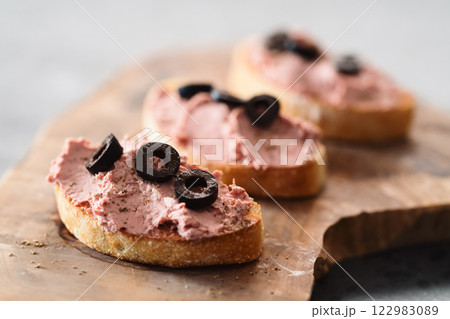 Ciabatta with meat paste on olive wowod board 122983089