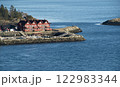 Traditional red wooden house by the rocky shore 122983344