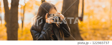 Banner Child girl using an old-fashioned camera in autumn nature. Photographer, fall season and leisure concept. Copy space Banner Child girl using an old-fashioned camera in autumn nature. Photographer, fall season and leisure concept. Copy space 122983737