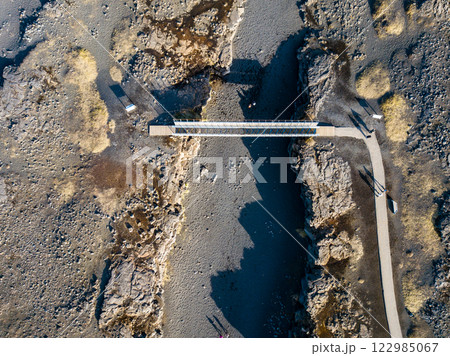 Aerial of the bridge connecting the north american and eurasian tectonic plates at Reykjanes, showcasing the dramatic rift between two major geological boundaries 122985067
