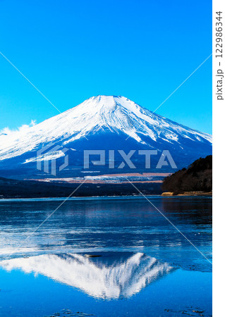 山中湖から見た冬の晴れた空と雪化粧する厳冬の逆さ富士 122986344