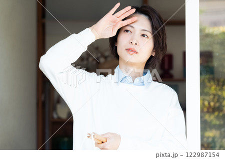 リビングから外を見る女性 122987154