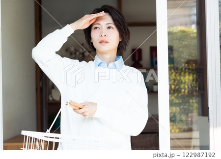 リビングから外を見る女性 122987192