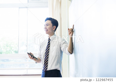 先生　教師　授業　黒板　笑顔　男性　タブレット 122987455