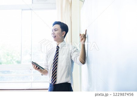 先生　教師　授業　黒板　笑顔　男性　タブレット 122987456