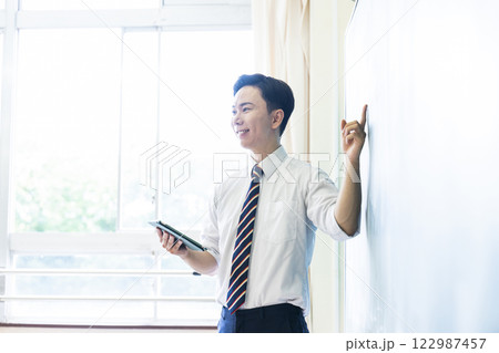 先生　教師　授業　黒板　笑顔　男性　タブレット 122987457