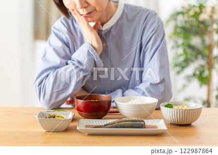 和食の朝食を前に悩むミドル女性 和食の朝食を前に悩むミドル女性 122987864